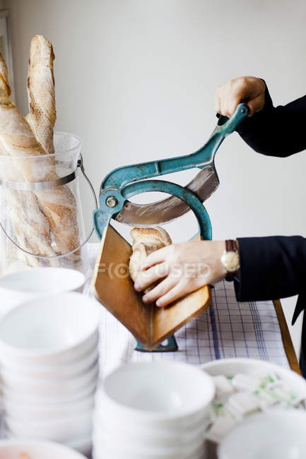Руки режут хлеб буханку — стоковое фото
