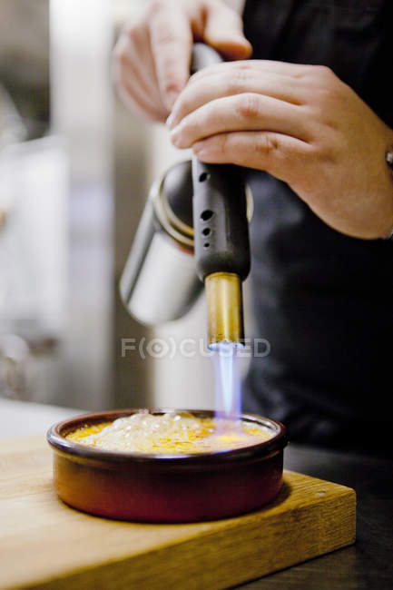 Chef caramelizante creme brulee — Fotografia de Stock