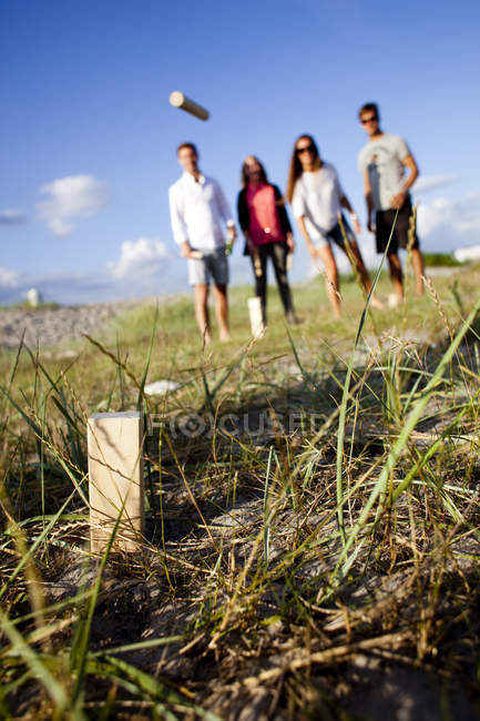 Young friends playing kubb game — Stock Photo