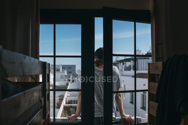 Молодой человек стоит на балконе — стоковое фото