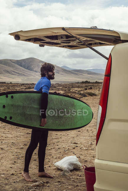 Joven surfista sosteniendo tabla de surf - foto de stock