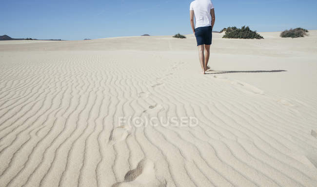 Young man walking in desert — Stock Photo
