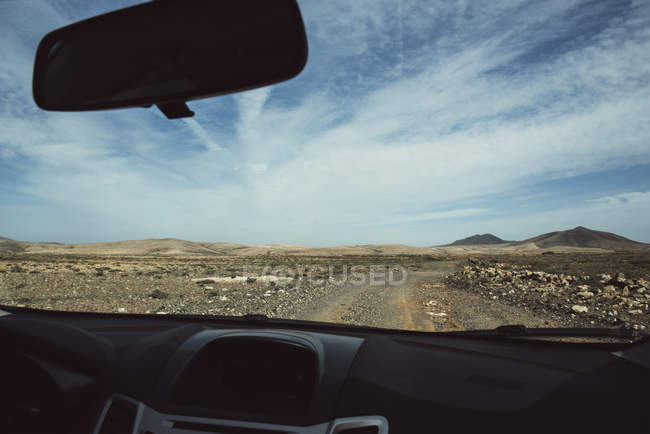 Camino del desierto visto desde el coche - foto de stock