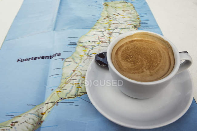 Fresh coffee cup on map — Stock Photo
