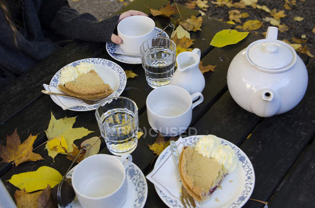 Mujer comiendo pastel al aire libre - foto de stock