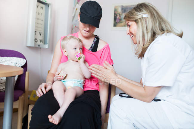 Bebé siendo examinado por el médico - foto de stock