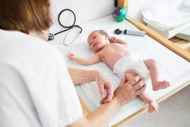 Bebé siendo examinado por el médico - foto de stock