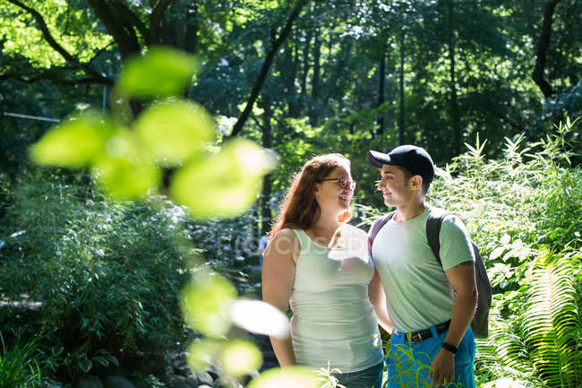Couple among trees in park — Stock Photo