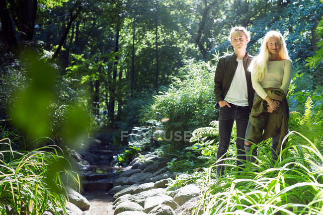 Teenage couple standing by stream — Stock Photo