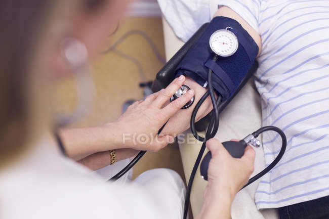 Médico midiendo presión arterial - foto de stock