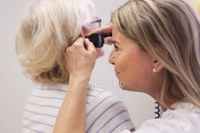 Docteur examinant l'oreille — Photo de stock