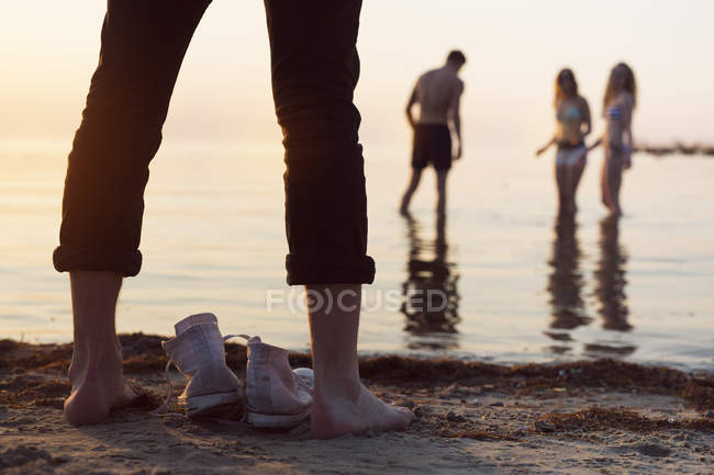 Молодий чоловік стоїть на пляжі — стокове фото