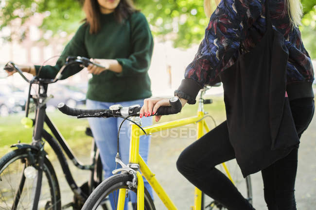 Young women with bicycles — Stock Photo