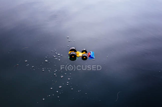 Coche de juguete en la superficie del agua - foto de stock