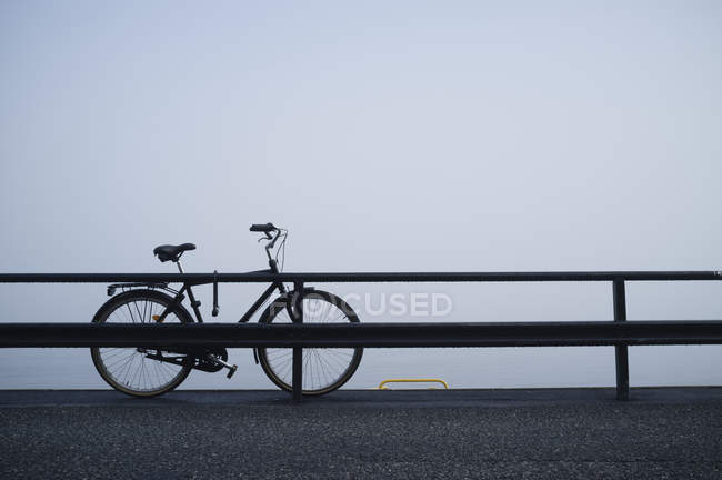 Брошенный велосипед за перилами — стоковое фото