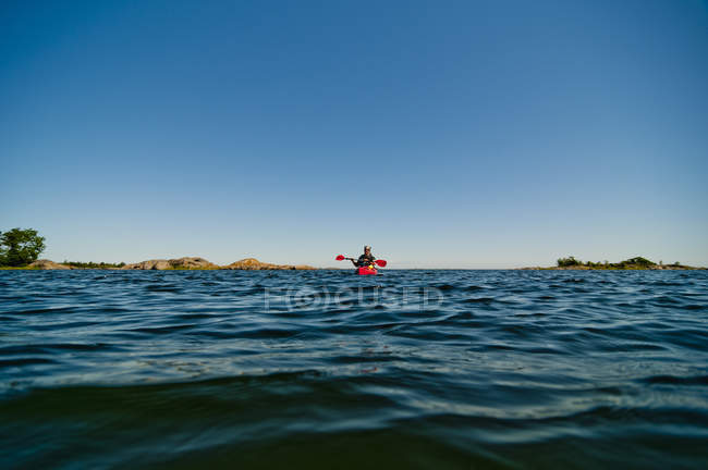Homem remando no mar ao pôr do sol — Fotografia de Stock