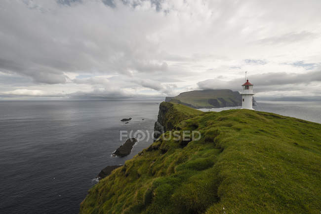 Lighthouse by sea on cloudy day — Stock Photo