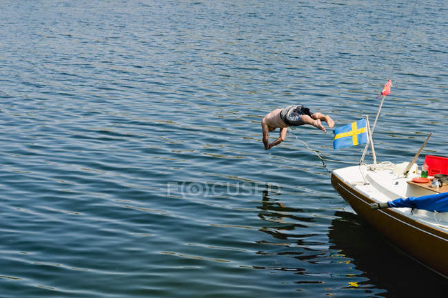 Мужчина без рубашки прыгает в море — стоковое фото