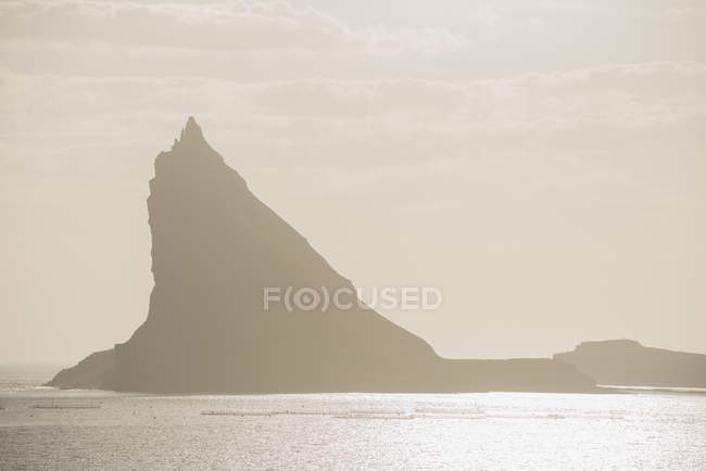 Silhouette of mountain by sea — Stock Photo
