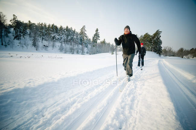 Casal esqui no campo de neve — Fotografia de Stock