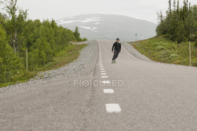 Uomo skateboard su strada — Foto stock