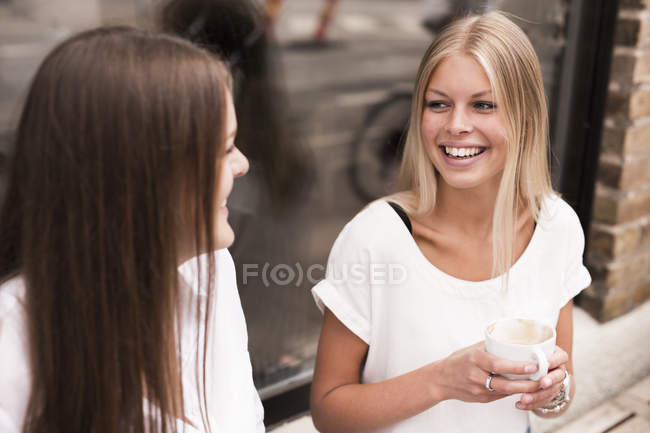 Women talking outside of cafe — Stock Photo