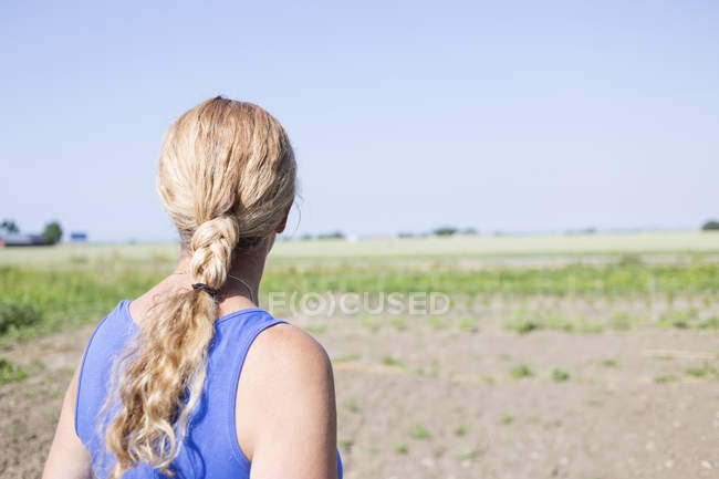 Mulher olhando para o campo — Fotografia de Stock