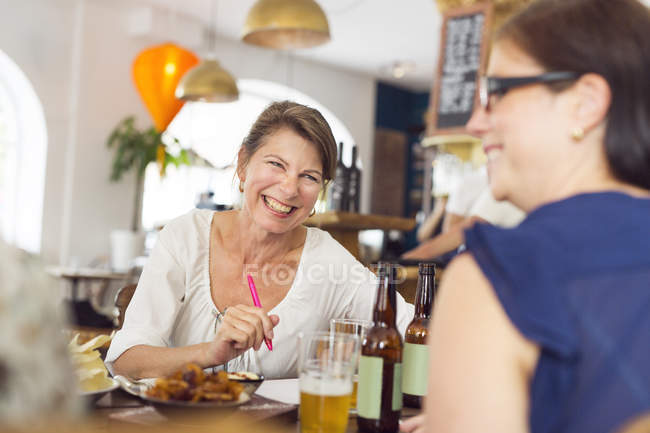 Mulheres rindo durante o almoço — Fotografia de Stock