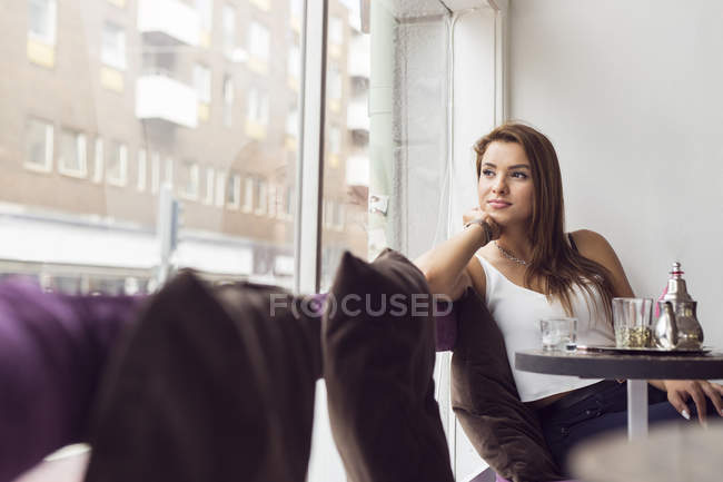 Mulher olhando através da janela — Fotografia de Stock