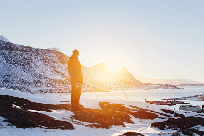 Homem olhando para a vista ao pôr do sol — Fotografia de Stock