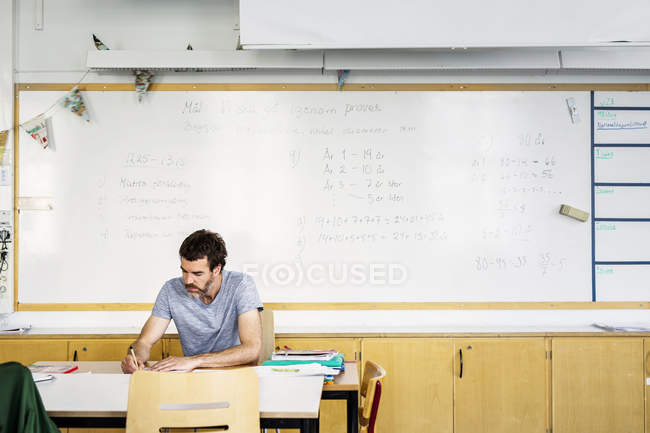 Вчитель сидить за столом — стокове фото