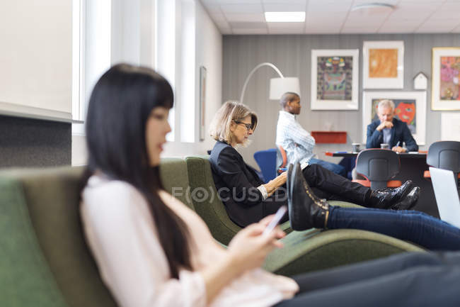 Colegas sentados en una oficina moderna - foto de stock