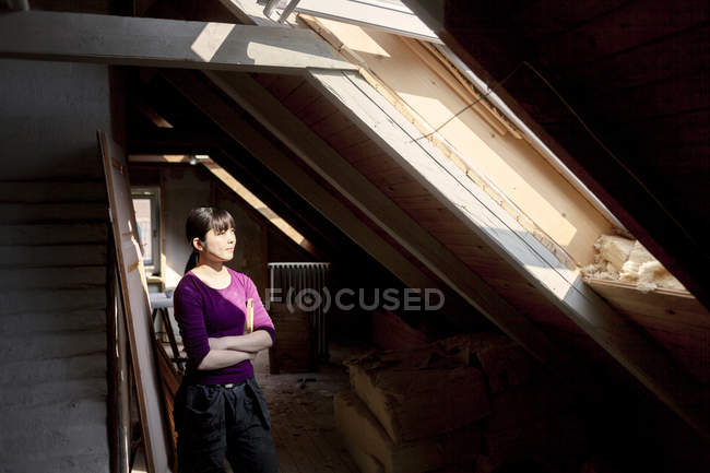 Frau steht auf altem Dachboden — Stockfoto