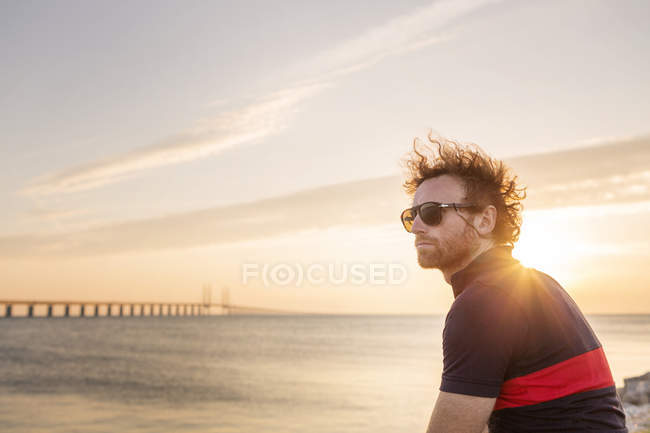 Чоловік на скелястій береговій лінії на заході сонця — стокове фото