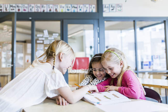 Meninas aprendendo em sala de aula com livros didáticos — Fotografia de Stock