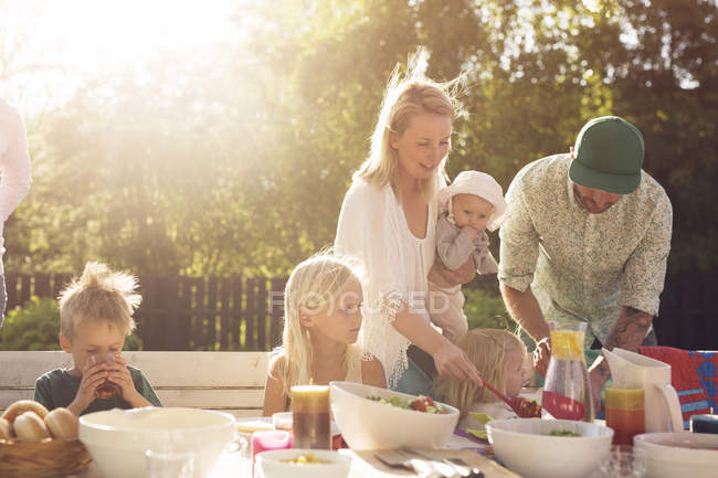 Семья с четырьмя детьми за столом для пикника — стоковое фото