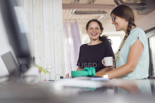 Жінки посміхаються в сучасному офісі — стокове фото