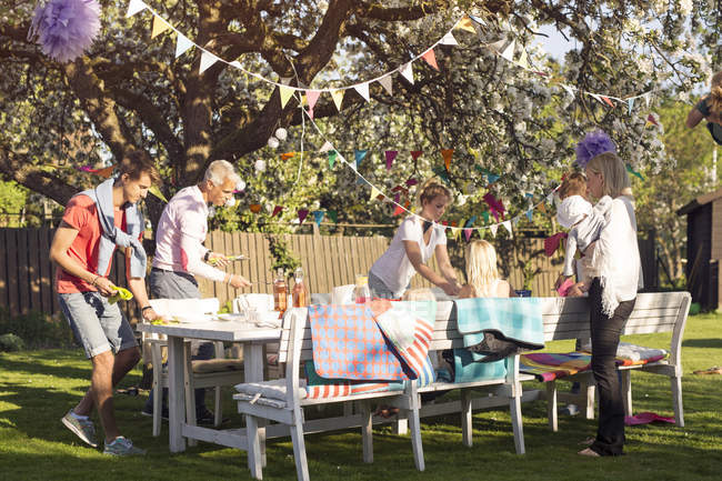 Famiglia che prepara tavolo al picnic in giardino — Foto stock