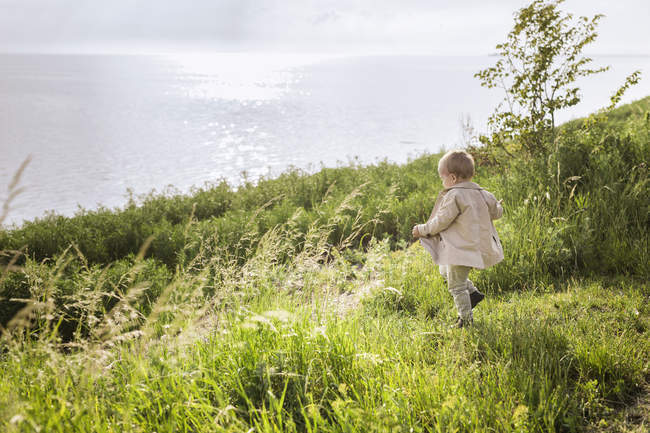 Хлопчик ходить на зеленому лузі — стокове фото