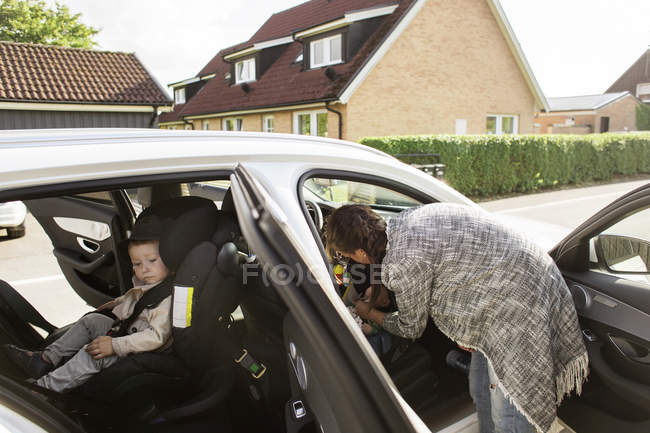 Mother fastening sons seat belts — Stock Photo