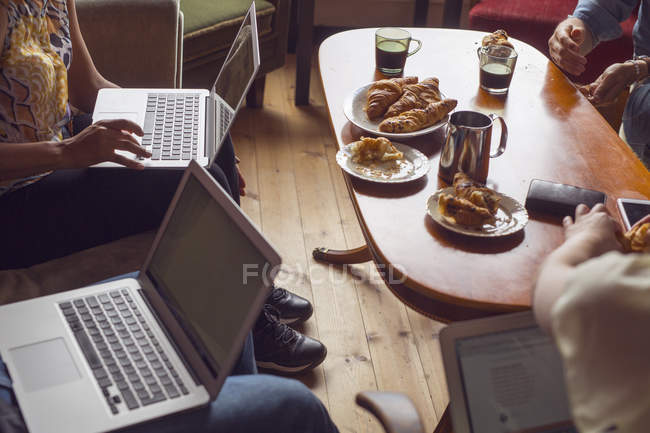 Colleagues having lunch with laptops — Stock Photo