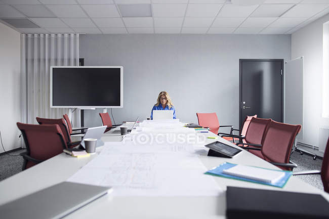 Femme travaillant dans une pièce vide — Photo de stock