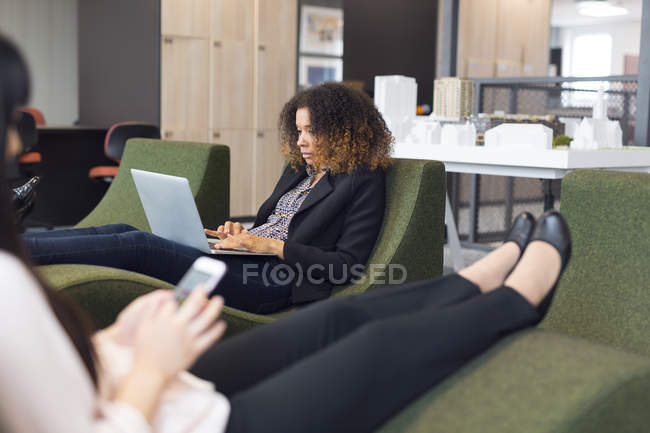 Mulheres usando smartphone e laptop — Fotografia de Stock