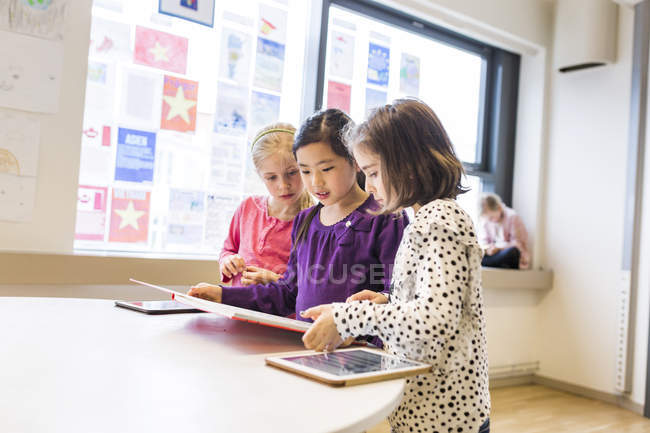 Girls learning in classroom with tablets — Stock Photo