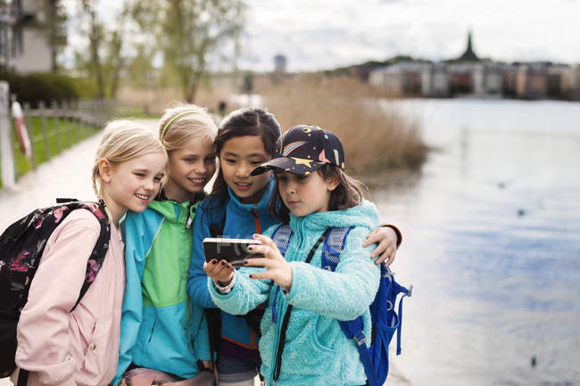Girls taking selfie by river — Stock Photo