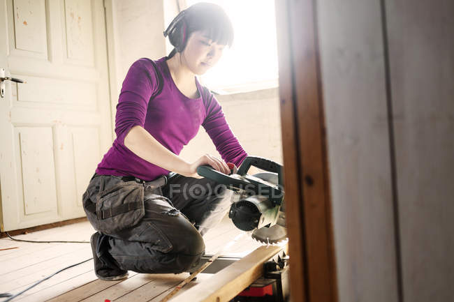 Femme travaillant avec du bois et scie circulaire — Photo de stock