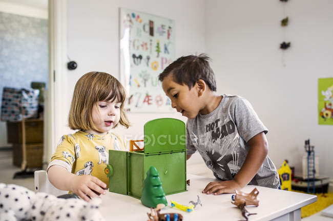 Ragazza e ragazzo giocare con i giocattoli — Foto stock
