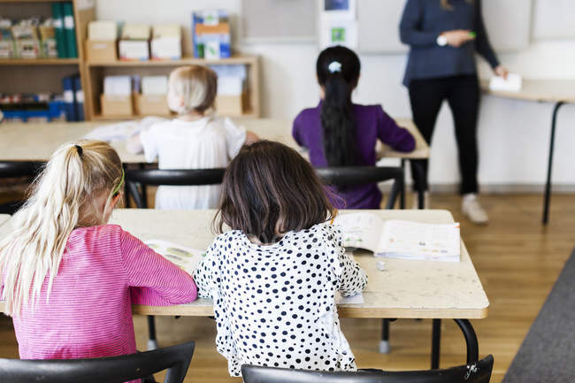 Four girls learning in classroom — Stock Photo