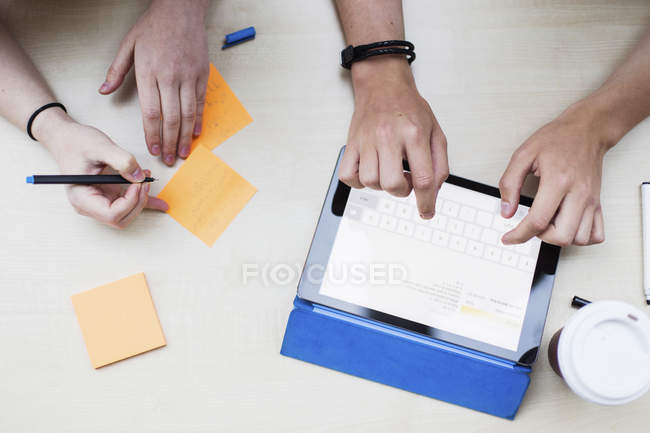 Close-up view of students writing notes and working with digital tablet — Stock Photo