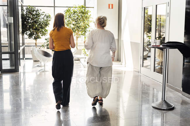 Mujeres caminando en el vestíbulo - foto de stock